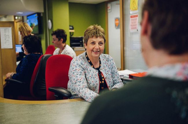 Woman sat behing counter