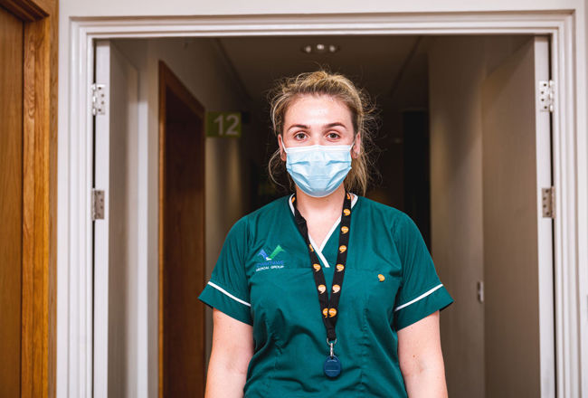 Nurse wearing a Iaith Gwaith lanyard