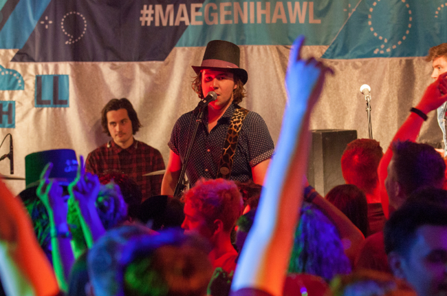 Photo of band playing with 'Mae Gen i Hawl' baner in the background