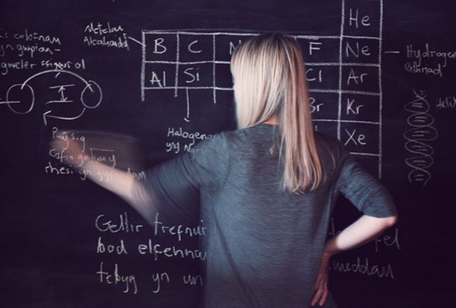 Teacher writing on a blackboard