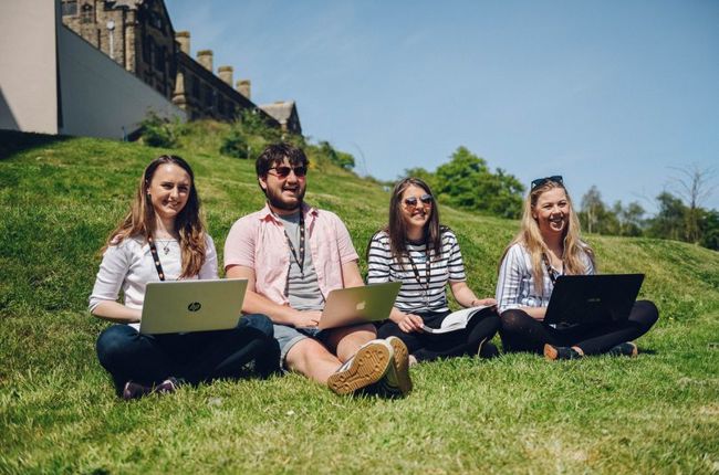 Group of young people sitting on grass