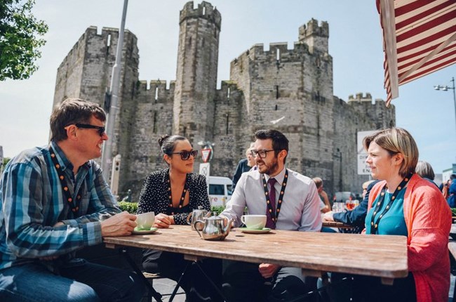 A group sitting by Caernarfon castle
