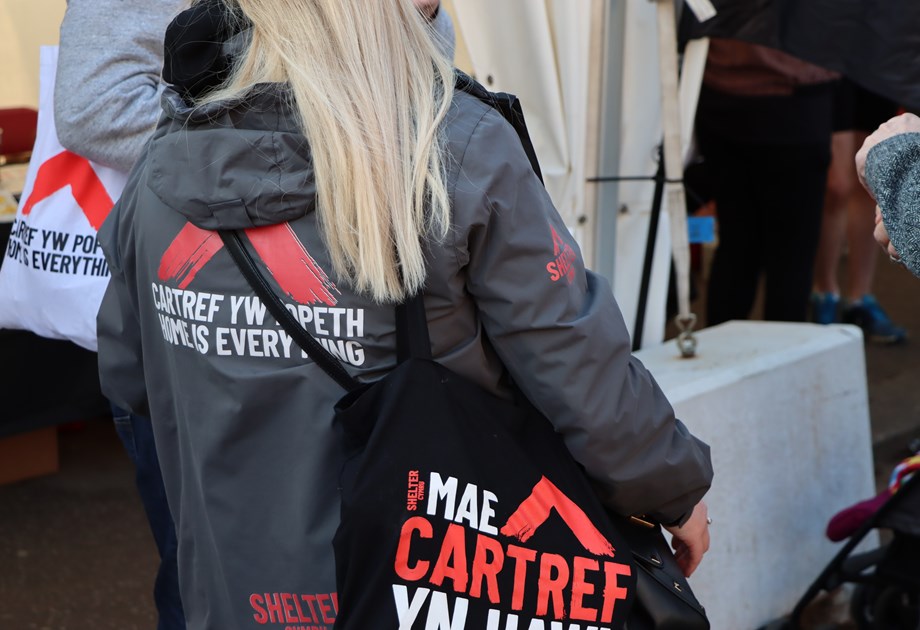 Woman wearing Shelter Cymru coat and bag