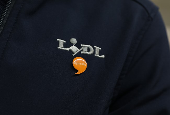 Jacket with Lidl logo and Iaith Gwaith badge