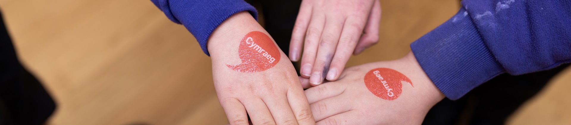 Hands with iaith gwaith logo