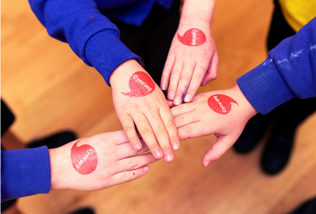 Iaith Gwaith logo on hands