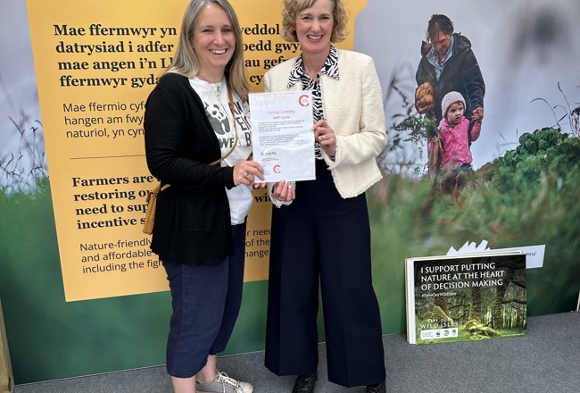 Welsh Language Commissioner presenting the Cynnig Cymraeg certificate to the WWF