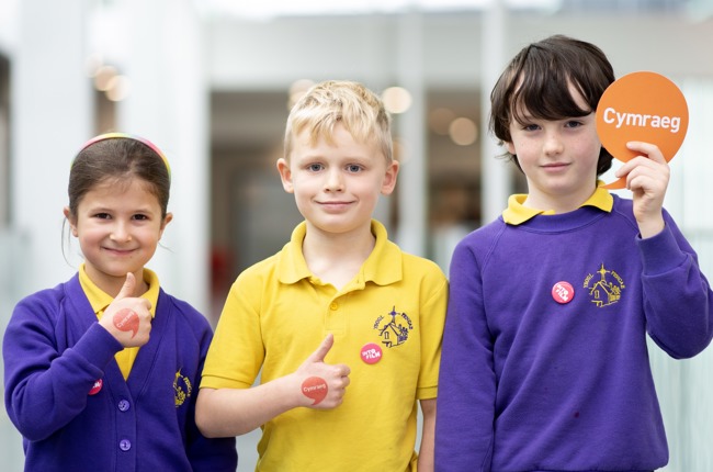 Image of children holding iaith gwaith badge